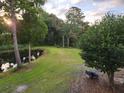 Picturesque backyard featuring a serene pond, lush green lawn, and mature trees at 7997 Doar Rd # C-3, Awendaw, SC 29429
