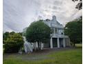 Charming white house with multi-level balconies, surrounded by lush trees and greenery at 7997 Doar Rd # C-3, Awendaw, SC 29429