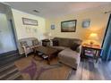 Comfortable living room featuring a cozy couch, wood laminate flooring, and stylish decor at 855 Club Cottage Rd, Edisto Island, SC 29438