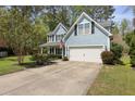 Inviting two-story home with a well-manicured lawn, two-car garage, and charming front porch at 8566 Royal Palm Ln, North Charleston, SC 29420