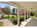 Inviting porch with classic white columns, lush landscaping, and shade provides a welcoming outdoor space at 8566 Royal Palm Ln, North Charleston, SC 29420