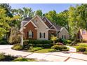 Charming home with a well-manicured lawn, mature trees, and a circular driveway at 8642 W Fairway Woods Dr, North Charleston, SC 29420