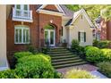 Close-up of the home's front entrance with stairs, greenery, and a classic brick design at 8642 W Fairway Woods Dr, North Charleston, SC 29420