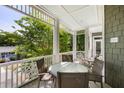 Charming balcony showcasing a cozy seating area with serene views of the surrounding trees and neighborhood at 9 24Th Ave, Isle of Palms, SC 29451