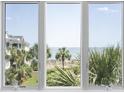 Bright view from a picture window overlooking palm trees, dunes, and the ocean at 9000 Palmetto Drive # D-304, Isle of Palms, SC 29451
