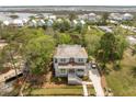 Stunning aerial view of coastal home with wood roof and lush landscaping near marsh and other residences at 1006 Basin Ln, Johns Island, SC 29455