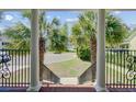 Inviting front porch view with white pillars and black railings, framing the neighborhood at 105 Aviary Ct, Summerville, SC 29483