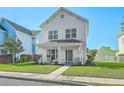 Charming two-story white home featuring a cozy front porch with seating and a well-manicured lawn at 107 Amaranth Ave, Summerville, SC 29483