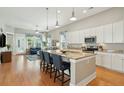 Bright, open kitchen boasts white cabinets, granite countertops, a kitchen island, and seamless connection to the living area at 112 Starling St, Summerville, SC 29483