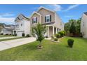 Corner view of a two-story house with a well-manicured lawn and a small tree in the front yard at 121 Dream St, Summerville, SC 29483