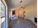 Open-concept living room with fireplace, tile flooring, ceiling fan, and an open kitchen with natural light at 124 Droos Way, Charleston, SC 29414