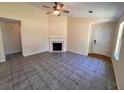 Spacious living room with tile flooring, fireplace, and abundant natural light from nearby windows and a ceiling fan at 124 Droos Way, Charleston, SC 29414
