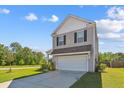 Two-story home with a two-car garage, set on a verdant lot with mature trees at 136 Pontoria Dr, Summerville, SC 29483