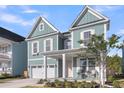 Attractive two-story home with a covered front porch, well-maintained landscaping, and a garage at 1541 Homecoming Blvd, Ravenel, SC 29470