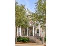 Lovely brick home featuring a classic front porch with white columns and manicured landscaping at 185 River Green Pl, Daniel Island, SC 29492