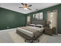 Bedroom with dark green accent wall, plush carpet, ceiling fan, and a comfortable gray bed at 1953 Suzanne St, Johns Island, SC 29455