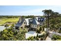 Stately home overlooking lush greenery and a golf course with a pristine driveway and manicured landscaping at 20 Old Cedar Ln, Kiawah Island, SC 29455
