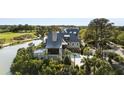 Elegant home with lush greenery and water views, featuring a pristine driveway and sophisticated landscaping at 20 Old Cedar Ln, Kiawah Island, SC 29455