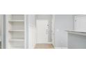 Inviting light-gray entryway with white doors, trim and shelving, offering a clean and organized entrance at 200 Bucksley Ln # 302, Charleston, SC 29492