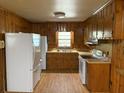 Cozy kitchen with wood paneling, white appliances, and ample cabinet space at 2438 Two Oaks Dr, Charleston, SC 29414