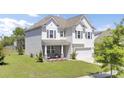 Charming two-story home with a well-manicured lawn, inviting front porch, and a two car garage at 2746 Sunrose Ln, Johns Island, SC 29455