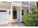 Inviting front entryway with a wood door, stylish lanterns, brick walkway, and lush landscaping for added curb appeal at 2828 Olivia Marie Ln, Johns Island, SC 29455