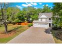 Beautiful home featuring a well-manicured lawn, brick driveway, a double garage, and classic Southern charm at 2828 Olivia Marie Ln, Johns Island, SC 29455