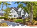 A light blue two-story home featuring a driveway, green lawn, and mature trees in a serene neighborhood setting at 3500 Maplewood Ln, Mount Pleasant, SC 29466