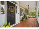 Inviting front porch with wood floors, swing, and decorative wreath on front door at 3526 Stockton Dr, Mount Pleasant, SC 29466