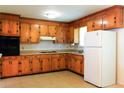 Traditional kitchen featuring wood cabinets, a white refrigerator, and ample counter space for meal preparation at 356 Price St, Goose Creek, SC 29445