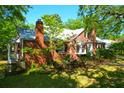 A red brick home showcases a new metal roof, lush green landscaping, and a brick chimney at 41 Berkeley Rd, Charleston, SC 29407