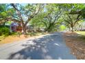 A quaint red brick home sits on a tree-lined street, offering a picturesque setting and curb appeal at 41 Berkeley Rd, Charleston, SC 29407