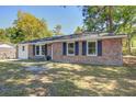 Inviting single-story brick home with black shutters, lush front lawn, and mature trees at 4412 Garwood Dr, Ladson, SC 29456
