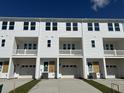 Modern townhome exterior shows white siding, individual garages, and second story balconies at 5114 Double Eagle Loop, Summerville, SC 29485