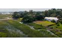 Aerial view of a home by a marsh featuring mature trees and a dock at 561 Seaward Dr, Charleston, SC 29412