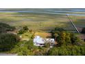 An aerial view captures a cozy home with a metal roof near marshlands and waterfront at 561 Seaward Dr, Charleston, SC 29412