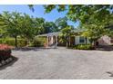 Charming home with a large gravel driveway, lush landscaping, and inviting covered entry at 5907 Murray Dr, Hanahan, SC 29410
