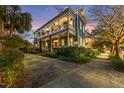 Beautiful two-story home with a wrap-around porch, lush landscaping, and a long driveway at 66 Warren St # Main House Only, Charleston, SC 29403