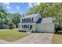 Charming two-story home featuring a covered front porch, attached two car garage, and landscaped front yard at 8363 Water Ash Way, North Charleston, SC 29420