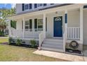 Inviting front porch with white railings, steps, and a blue front door at 8363 at 8363 Water Ash Way, North Charleston, SC 29420