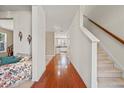 Bright hallway with hardwood floors leading to the carpeted stairs and living area at 8956 N Red Maple Cir, Summerville, SC 29485