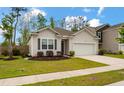 Lovely home with manicured front lawn, walkway, driveway, and attached garage at 9781 Roseberry St, Ladson, SC 29456