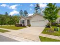 Well-maintained home with a spacious driveway, landscaped yard, and attached garage at 9781 Roseberry St, Ladson, SC 29456