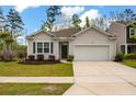 Charming single-story home with a well-manicured lawn, inviting curb appeal, and an attached two-car garage at 9781 Roseberry St, Ladson, SC 29456