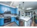 Bright kitchen featuring modern blue cabinetry, stainless appliances, and stylish lighting fixtures at 1025 Riverland Woods Pl # 1108, Charleston, SC 29412