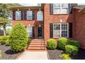 Inviting brick front entrance with landscaped bushes, black shutters, and stairs at 105 Kirkhaven Ct, Goose Creek, SC 29445