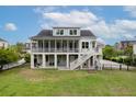 Expansive backyard view with outdoor patio, a large screened porch, a staircase to the fenced yard, and lush landscaping at 1104 Beresford Run, Charleston, SC 29492