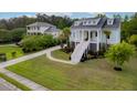 Charming two-story home with a welcoming staircase and columns, a circular driveway, and lush landscaping at 1104 Beresford Run, Charleston, SC 29492