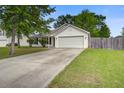 Charming single-story home featuring a manicured lawn, mature trees, and an attached two-car garage at 1341 Belle Grove Cir, Hanahan, SC 29410
