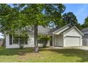 Well-maintained single-story home with green lawn and mature landscaping, complete with an attached garage at 1341 Belle Grove Cir, Hanahan, SC 29410